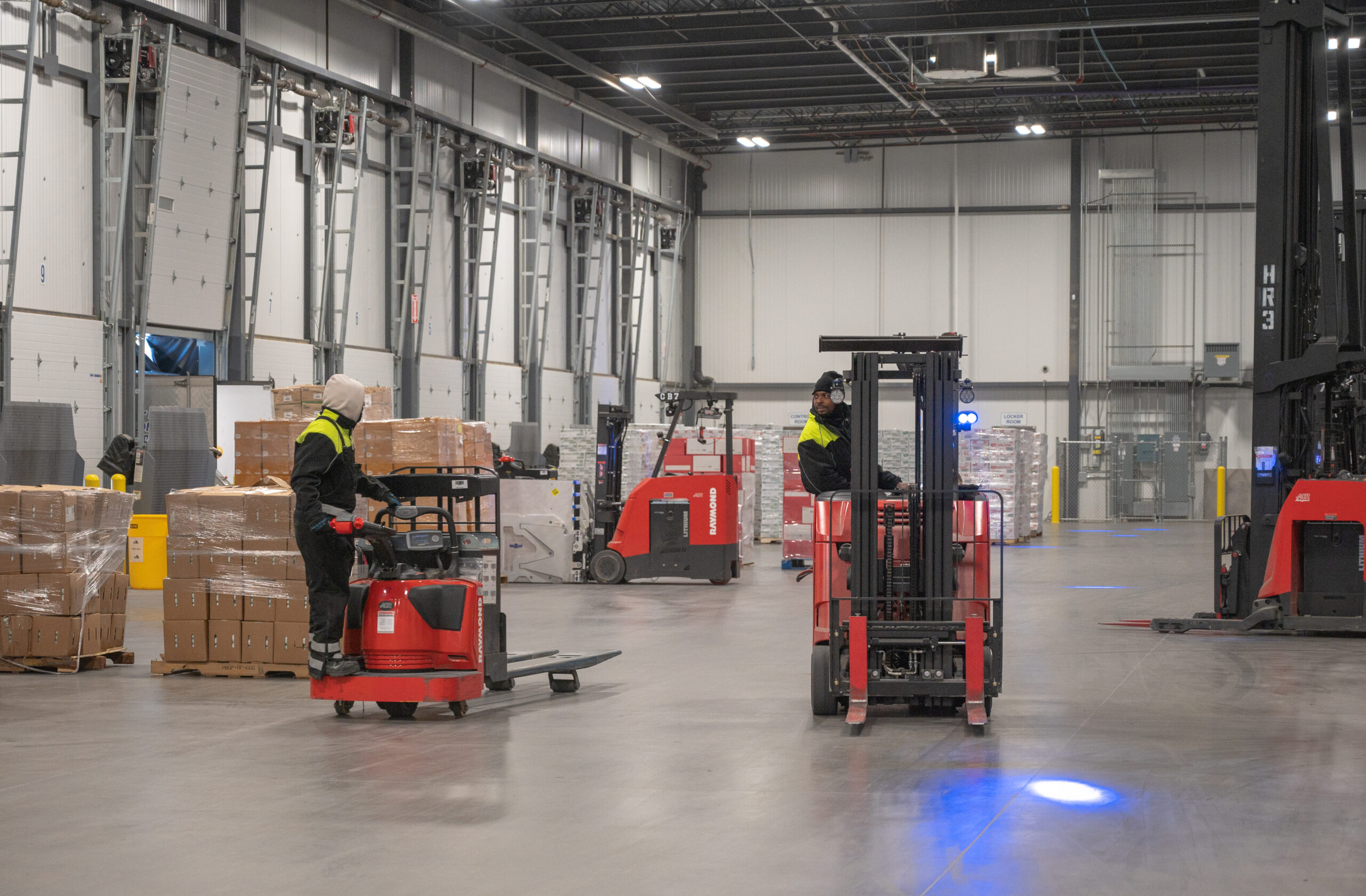 Two workers operating forklifts in Arcadia Cold’s Atlanta facility, showcasing efficiency in cold storage operations.